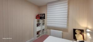 Un dormitorio con una cama y una ventana con persianas. en Arribolas, en Bermeo
