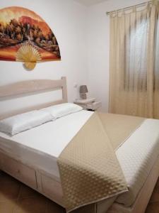 a bedroom with a bed with a painting on the wall at La rosa dei venti in Santa Teresa Gallura