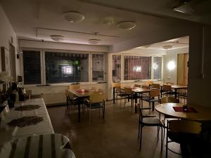 una sala da pranzo con tavoli, sedie e finestre di Kampus Sippola a Sippola