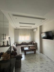 a living room with a couch and a table at Appartement climatisé avec balcon proche plage in Saïdia