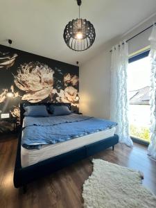 a bedroom with a bed with a painting on the wall at Silesia Apartments Ustron B129 in Ustroń