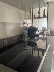 a kitchen with a counter and a glass wall at Appartement climatisé avec balcon proche plage in Saïdia
