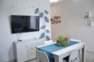 a dining room with a blue table and a tv at A Casuzza in Salemi