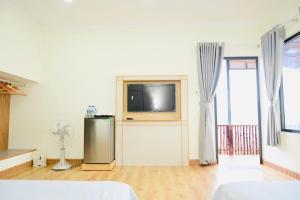 un soggiorno con TV a schermo piatto e ventilatore di The Sunset a Phan Thiet