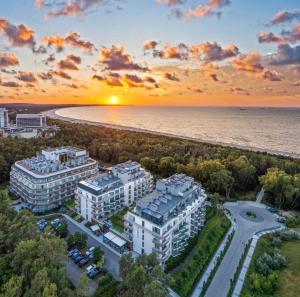an aerial view of condos and the beach at sunset at ApartPark Albus1 in Świnoujście