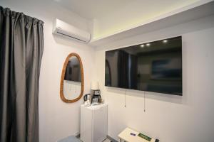 a living room with a tv and a mirror at Hermes Suite Klathmonos by Zeussuites in Athens