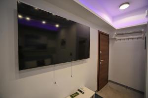 a room with a large flat screen tv on the wall at Hermes Suite Klathmonos by Zeussuites in Athens +40 photos