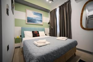 a bedroom with a bed with two towels on it at Hermes Suite Klathmonos by Zeussuites in Athens