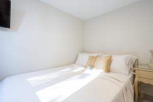 a white bed with white sheets and pillows at Nautilus house in Stalos
