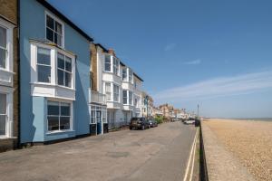 una calle con casas y coches aparcados en la playa en Shore View, Aldeburgh - A lovely Seafront House on famous Crag Path with uninterrupted Beach Views - Aldeburgh Coastal Cottages, en Aldeburgh