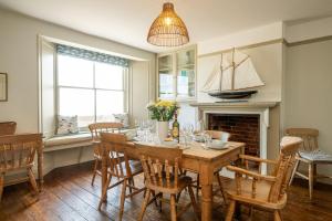 a dining room with a table and a sailboat on the window at Shore View, Aldeburgh - A lovely Seafront House on famous Crag Path with uninterrupted Beach Views - Aldeburgh Coastal Cottages in Aldeburgh