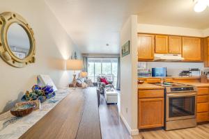 a kitchen with wooden cabinets and a counter top at Ocean Shores Condo with Balcony Less Than 1 Mi to Beach! in Ocean Shores
