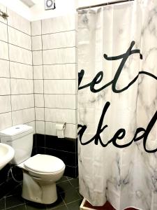 a bathroom with a toilet and a shower curtain with the words keep heard at Saint Gin Apartment in Shëngjin +27 photos