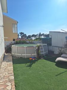 a small backyard with a tennis court in the yard at Bruno in Amora