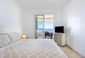 a bedroom with a bed and a desk with a television at Los Gigantes,luxury aircon, views and pools in Puerto de Santiago +31 photos