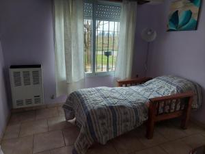 a bedroom with a bed and a window at Casa de Cande in Tandil