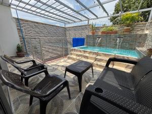 a patio with chairs and a swimming pool at Casa colonial - Jacuzzi - cerca al parque principal - lundry - Tv in Santa Fe de Antioquia