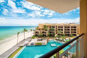 Una vista de la playa desde el balcón de un resort. en Condo Surf 408 - Beachfront Stunning Ocean View Penthouse - at El Faro condo, en Playa del Carmen