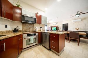 cocina con electrodomésticos de acero inoxidable y comedor en Condo Surf 408 - Beachfront Stunning Ocean View Penthouse - at El Faro condo, en Playa del Carmen