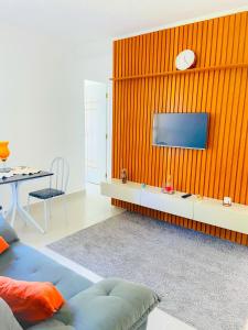 イリェウスにあるPerto da praia dos milionariosの壁にテレビが取り付けられたリビングルーム