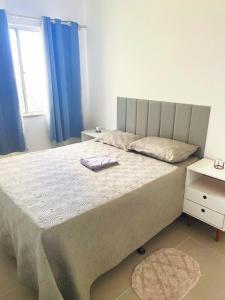 イリェウスにあるPerto da praia dos milionariosのベッドルーム1室(青いカーテン付きの大型ベッド1台付)