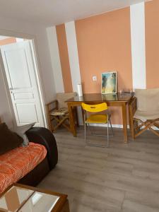 a living room with a table and a yellow chair at Igoumenitsa heart flats to let Mariasroom studios appart seaside-city Spyropoulos in Igoumenitsa