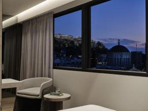 a room with a window with a view of a city at Nur Edge Aparthotel - Acropolis Skyline in Athens