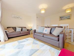 a living room with two couches and a rug at Oysters in West Wittering