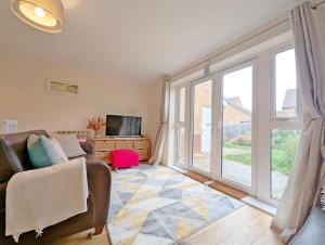a living room with a couch and a sliding glass door at Oysters in West Wittering