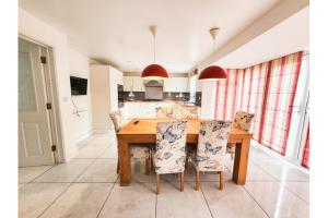 a kitchen with a wooden table and chairs at Homely Stays Taunton in Norton Fitzwarren