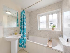 a bathroom with a tub and a sink and a toilet at Oysters in West Wittering +18 photos