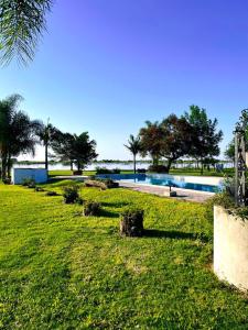 ein Park mit Swimmingpool und Palmen in der Unterkunft El viejo lobo in Esquina