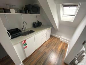 an attic kitchen with white cabinets and a sink at 6 New Street Bantry Studio Apartment 3 in Bantry