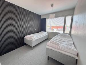 a bedroom with two beds and a window at Kolmio keskustasta in Ylivieska