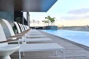 a row of white chairs and a swimming pool at Lobby 33 in Guadalajara
