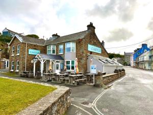 un bâtiment avec des tables à l'extérieur dans une rue dans l'établissement Beach Cottage, à Little Haven