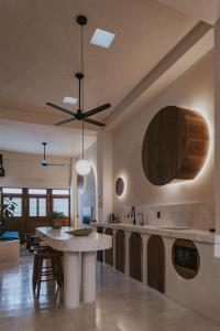 a kitchen with a table and a ceiling fan at Casa Chamaca - Paseo Montejo in Mérida