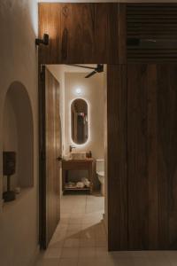 a bathroom with a toilet and a wooden door at Casa Chamaca - Paseo Montejo in Mérida +9 photos