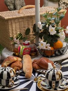 a table with bread and croissants and a basket of flowers at Villa Romana in Saint-Tropez
