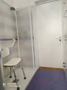 Habitación con silla y puerta corredera de cristal en La casa di nonna Lina al mare - senza barriere, en Torre del Lago Puccini