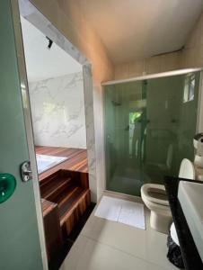 a bathroom with a glass shower and a toilet at Pousada Cantim de BH in Venda Nova +19 photos