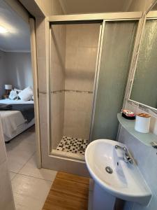 a bathroom with a shower and a sink at St Michaels Luxury Apartment in Amanzimtoti