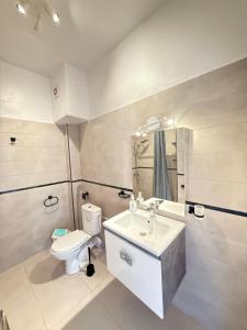 a white bathroom with a toilet and a sink at Résidence CHATT C3 in Cabo Negro