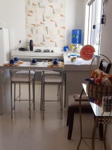 eine Küche mit zwei Barhockern und einer Arbeitsplatte in der Unterkunft Privacidade para sua família e grupos em um só lugar-2 quartos- melhor custo-benefício, garagem, sala com cozinha integrada, aconchegante, ambiente moderno e funcional, wi-fi veloz gratuito, próximo ao Parque das Águas-Calçadão e tudo que a cidade oferece in São Lourenço + 17 Fotos
