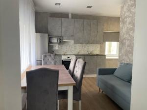 a kitchen with a wooden table and a blue couch at Mustvee aparts in Mustvee