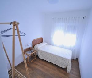 a small bedroom with a bed and a tripod at LA CURVA Orange Costa in Benicàssim