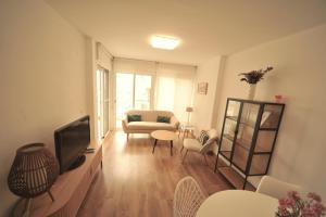 a living room with a television and a couch at LA CURVA Orange Costa in Benicàssim