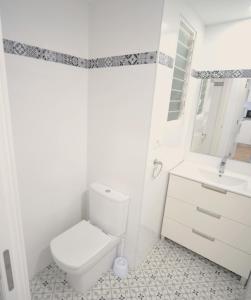a white bathroom with a toilet and a sink at LA CURVA Orange Costa in Benicàssim +9 photos