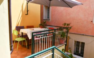 a balcony with a table and an umbrella at B&B Au Caruggiu in Ceriale