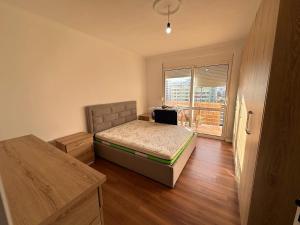 a bedroom with a bed and a large window at Ilir Daily Rent in Durrës